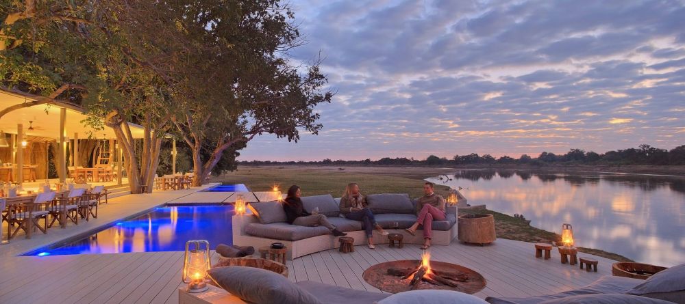 Sit around a campfire on the main deck overlooking the river's wildlife at Chinzombo, South Luangwa National Park, Zambia - Image 16