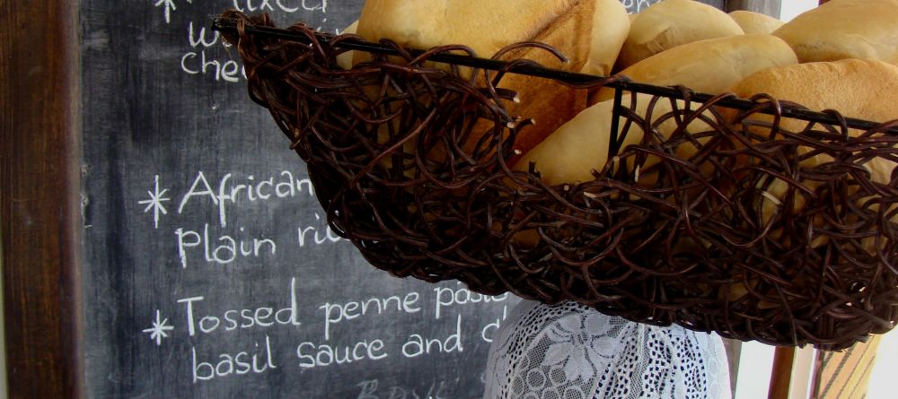 A local lady carrying bread on her head at Che Che Vule, Zanzibar, Tanzania - Image 1