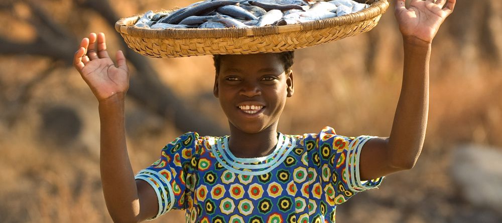 A local girl with preserved fish at Pumulani, Lake Malawi, Malawi - Image 12