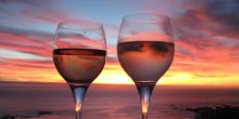 Enjoy a delicious glass of South African wine while watching the sunset at Camps Bay Beach, Cape Town, South Africa