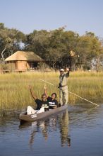 Staff in a recreational canoe at Xudum Okavango Delta Lodge, Okavango Delta, Botswana (AndBeyond)