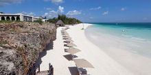 Rows of umbrellas and lounge chairs await guests along the spectacular beach at Hideaway of Nungwi Resort & Spa, Zanzibar, Tanzania