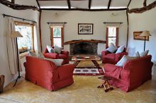 Comfortable chairs and African-inspired decor create a welcoming lounge at Mara House, Masai Mara National Reserve, Kenya