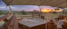 Let stress melt away as you soak in a hot tub overlooking the African sunsetr at Serengeti Bushtops Camp, Serengeti National Park, Tanzania
